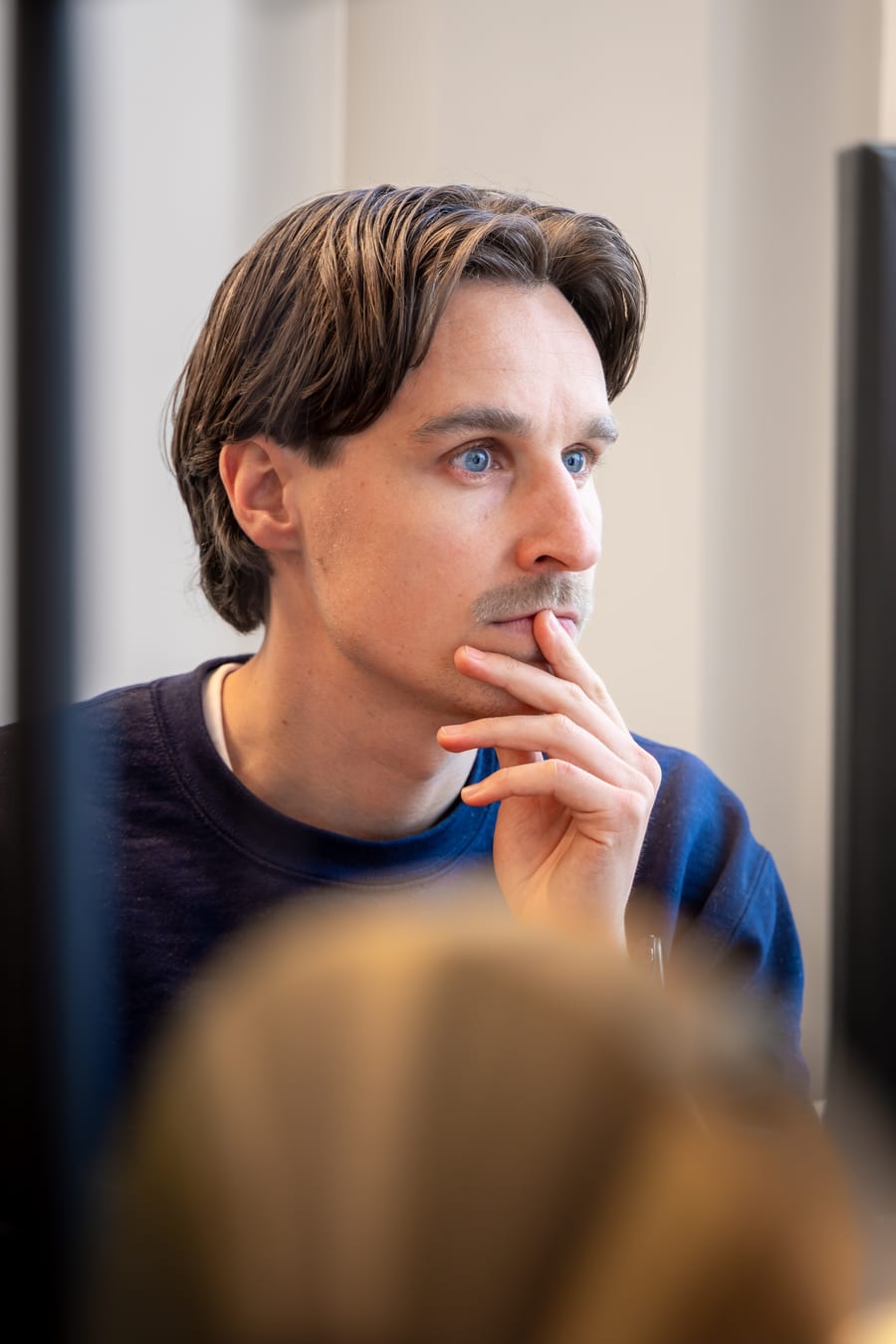 Iemand geconcentreerd achter een beeldscherm op kantoor
